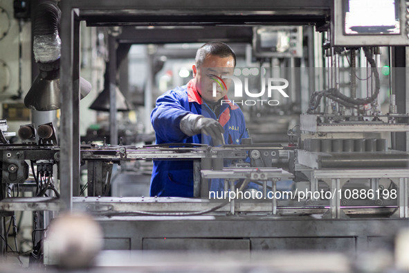 A worker is producing electronic products at a company in Xinghua, Jiangsu Province, China, on January 2, 2024. 