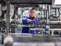 A worker is producing electronic products at a company in Xinghua, Jiangsu Province, China, on January 2, 2024. (