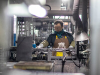 A worker is producing electronic products at a company in Xinghua, Jiangsu Province, China, on January 2, 2024. (