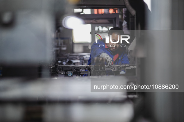 A worker is producing electronic products at a company in Xinghua, Jiangsu Province, China, on January 2, 2024. 