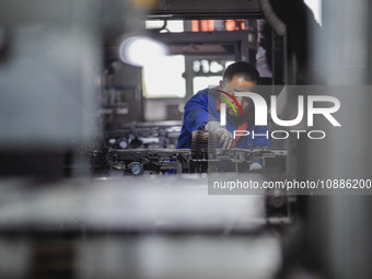 A worker is producing electronic products at a company in Xinghua, Jiangsu Province, China, on January 2, 2024. (