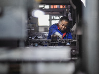 A worker is producing electronic products at a company in Xinghua, Jiangsu Province, China, on January 2, 2024. (