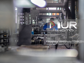 A worker is producing electronic products at a company in Xinghua, Jiangsu Province, China, on January 2, 2024. (