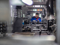 A worker is producing electronic products at a company in Xinghua, Jiangsu Province, China, on January 2, 2024. (