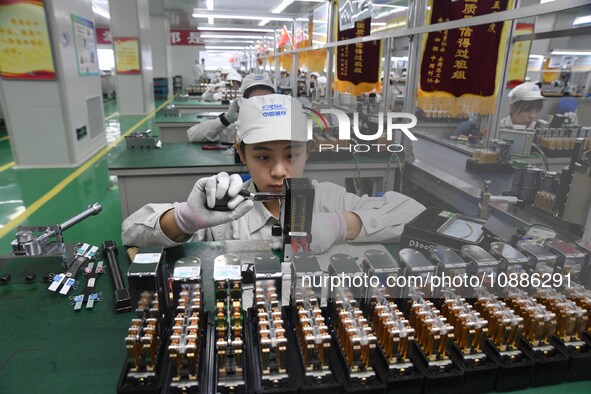 Workers are adjusting electrical equipment for railway signals in a workshop in Shenyang, Liaoning Province, China, on January 2, 2024. 