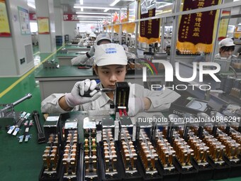 Workers are adjusting electrical equipment for railway signals in a workshop in Shenyang, Liaoning Province, China, on January 2, 2024. (