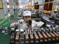 Workers are adjusting electrical equipment for railway signals in a workshop in Shenyang, Liaoning Province, China, on January 2, 2024. (