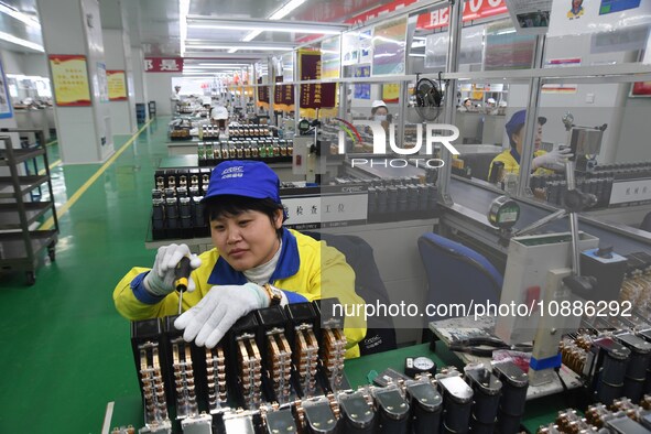 Workers are adjusting electrical equipment for railway signals in a workshop in Shenyang, Liaoning Province, China, on January 2, 2024. 