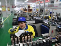 Workers are adjusting electrical equipment for railway signals in a workshop in Shenyang, Liaoning Province, China, on January 2, 2024. (