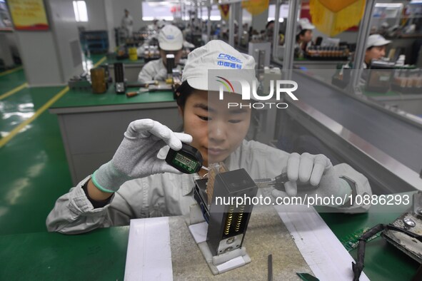 Workers are adjusting electrical equipment for railway signals in a workshop in Shenyang, Liaoning Province, China, on January 2, 2024. 