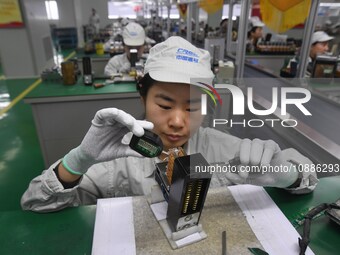 Workers are adjusting electrical equipment for railway signals in a workshop in Shenyang, Liaoning Province, China, on January 2, 2024. (