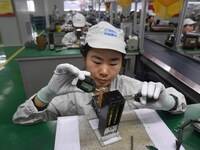 Workers are adjusting electrical equipment for railway signals in a workshop in Shenyang, Liaoning Province, China, on January 2, 2024. (