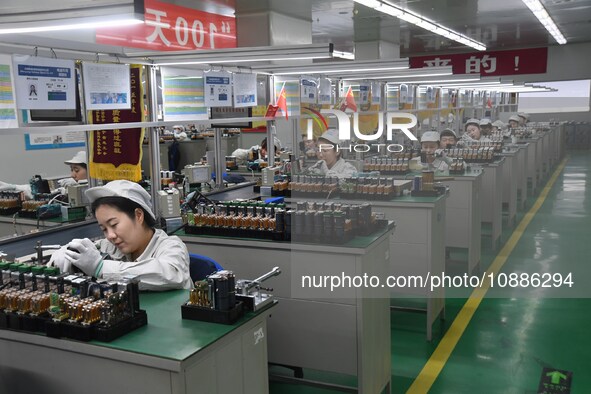 Workers are adjusting electrical equipment for railway signals in a workshop in Shenyang, Liaoning Province, China, on January 2, 2024. 