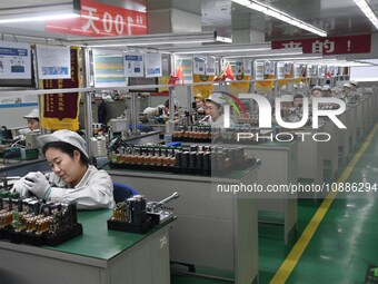 Workers are adjusting electrical equipment for railway signals in a workshop in Shenyang, Liaoning Province, China, on January 2, 2024. (