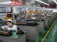 Workers are adjusting electrical equipment for railway signals in a workshop in Shenyang, Liaoning Province, China, on January 2, 2024. (