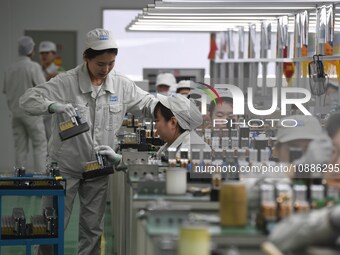 Workers are adjusting electrical equipment for railway signals in a workshop in Shenyang, Liaoning Province, China, on January 2, 2024. (