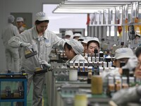 Workers are adjusting electrical equipment for railway signals in a workshop in Shenyang, Liaoning Province, China, on January 2, 2024. (