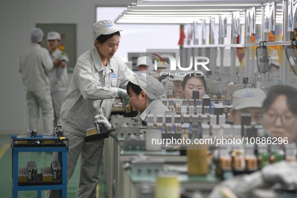 Workers are adjusting electrical equipment for railway signals in a workshop in Shenyang, Liaoning Province, China, on January 2, 2024. 