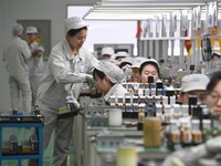 Workers are adjusting electrical equipment for railway signals in a workshop in Shenyang, Liaoning Province, China, on January 2, 2024. (