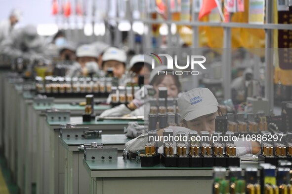 Workers are adjusting electrical equipment for railway signals in a workshop in Shenyang, Liaoning Province, China, on January 2, 2024. 