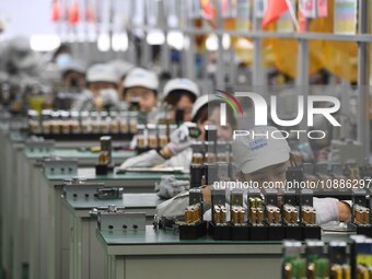 Workers are adjusting electrical equipment for railway signals in a workshop in Shenyang, Liaoning Province, China, on January 2, 2024. (