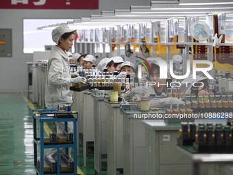 Workers are adjusting electrical equipment for railway signals in a workshop in Shenyang, Liaoning Province, China, on January 2, 2024. (