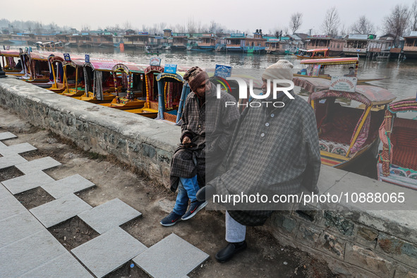 Shikara or boat owners are sitting on the banks of Dal Lake as they wait for tourists in Srinagar, Jammu and Kashmir, India, on January 3, 2...