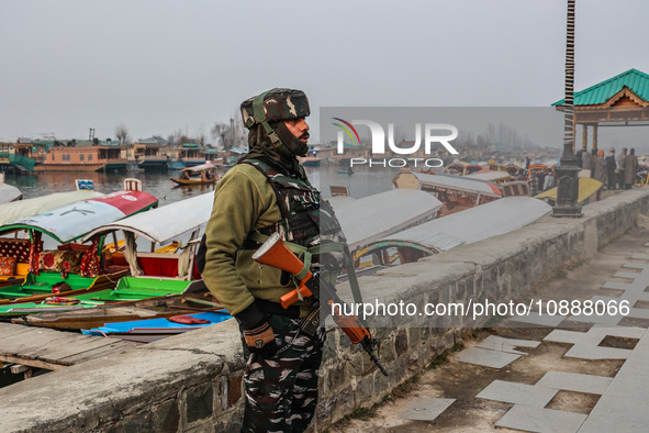 A CRPF trooper is standing alert on the banks of Dal Lake on a cold day in Srinagar, India, on January 3, 2023. 