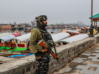 A CRPF trooper is standing alert on the banks of Dal Lake on a cold day in Srinagar, India, on January 3, 2023. (