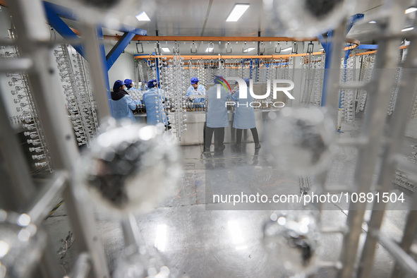 Workers are working in a production workshop of a bottle cap company in Tashan town, Ganyu district, Lianyungang city, Jiangsu province, Eas...