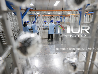 Workers are working in a production workshop of a bottle cap company in Tashan town, Ganyu district, Lianyungang city, Jiangsu province, Eas...