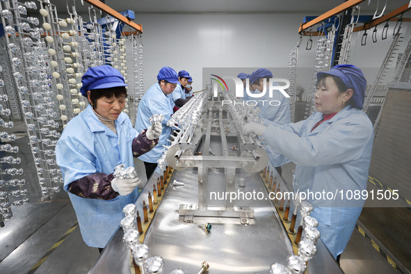 Workers are working in a production workshop of a bottle cap company in Tashan town, Ganyu district, Lianyungang city, Jiangsu province, Eas...