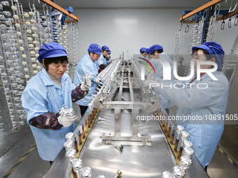 Workers are working in a production workshop of a bottle cap company in Tashan town, Ganyu district, Lianyungang city, Jiangsu province, Eas...