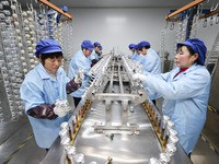 Workers are working in a production workshop of a bottle cap company in Tashan town, Ganyu district, Lianyungang city, Jiangsu province, Eas...