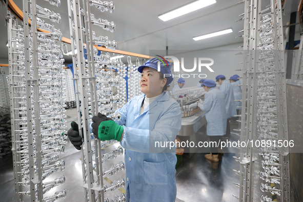 Workers are working in a production workshop of a bottle cap company in Tashan town, Ganyu district, Lianyungang city, Jiangsu province, Eas...