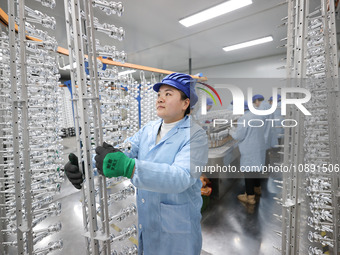 Workers are working in a production workshop of a bottle cap company in Tashan town, Ganyu district, Lianyungang city, Jiangsu province, Eas...