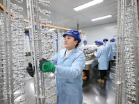 Workers are working in a production workshop of a bottle cap company in Tashan town, Ganyu district, Lianyungang city, Jiangsu province, Eas...