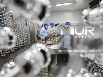 Workers are working in a production workshop of a bottle cap company in Tashan town, Ganyu district, Lianyungang city, Jiangsu province, Eas...