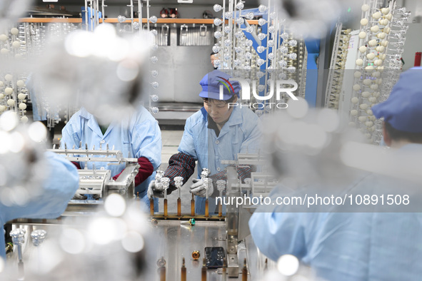 Workers are working in a production workshop of a bottle cap company in Tashan town, Ganyu district, Lianyungang city, Jiangsu province, Eas...