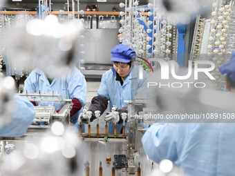 Workers are working in a production workshop of a bottle cap company in Tashan town, Ganyu district, Lianyungang city, Jiangsu province, Eas...