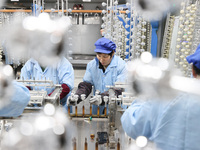 Workers are working in a production workshop of a bottle cap company in Tashan town, Ganyu district, Lianyungang city, Jiangsu province, Eas...