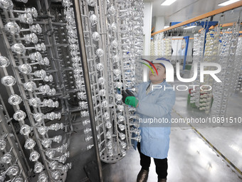 A worker is working at a production workshop of a bottle cap company in Tashan town, Ganyu district, in Lianyungang, China, on January 5, 20...