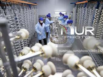 Workers are working in a production workshop of a bottle cap company in Tashan town, Ganyu district, Lianyungang city, Jiangsu province, Eas...