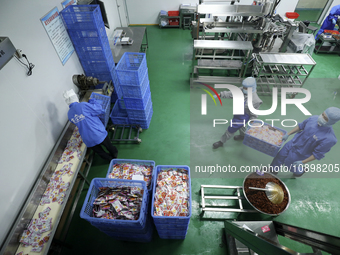 Workers are producing fish products at a workshop of a natural food company in Zixing, China, on January 4, 2024. (