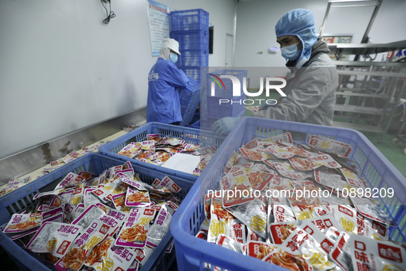 Workers are producing fish products at a workshop of a natural food company in Zixing, China, on January 4, 2024. 