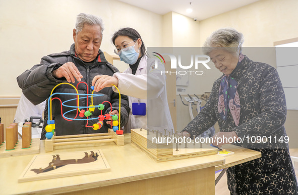 An elderly man is being escorted by medical staff during rehabilitation training in the rehabilitation sports function room of the Wuyang St...