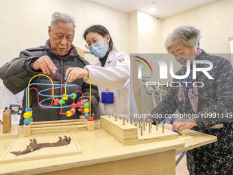 An elderly man is being escorted by medical staff during rehabilitation training in the rehabilitation sports function room of the Wuyang St...