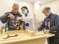 An elderly man is being escorted by medical staff during rehabilitation training in the rehabilitation sports function room of the Wuyang St...