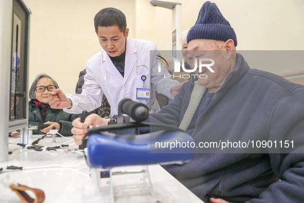 An elderly man is being escorted by medical staff during rehabilitation training in the rehabilitation sports function room of the Wuyang St...