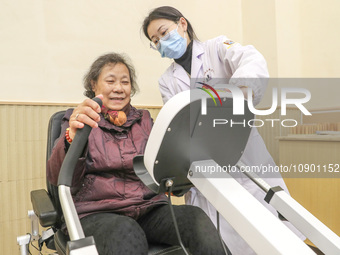 An elderly man is being escorted by medical staff during rehabilitation training in the rehabilitation sports function room of the Wuyang St...